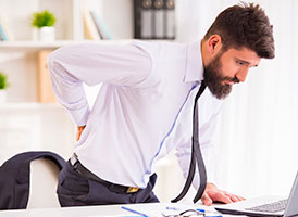 Mann mit Rückenschmerzen im Büro