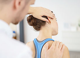 Therapeut legt Hände auf Kopf und Schulter einer Patientin